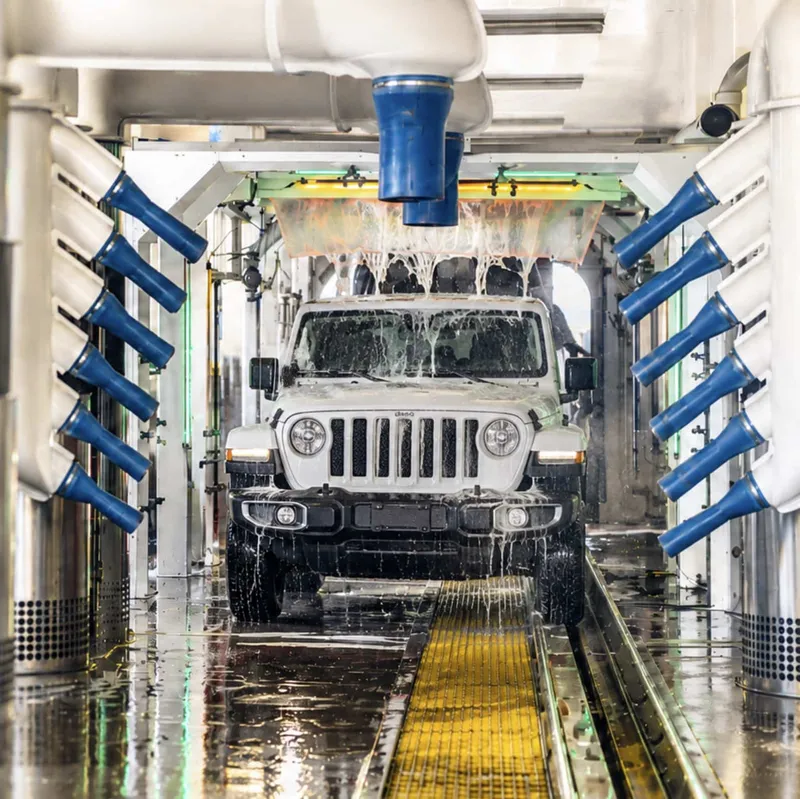 A white Jeep getting foamed as it moves through the Redondo Beach car wash tunnel.